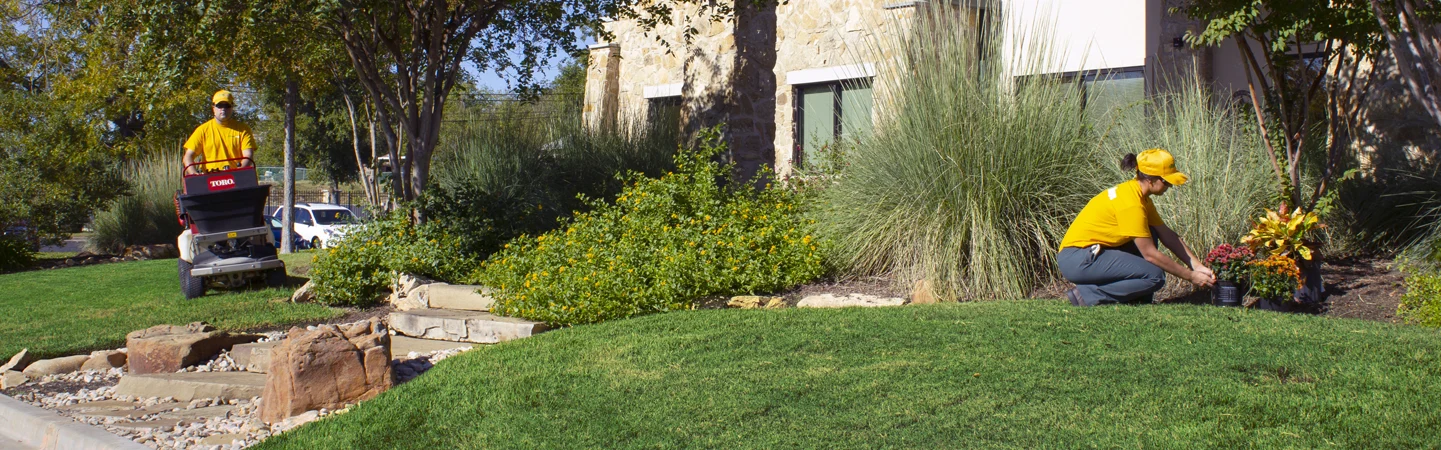 The Grounds Guys header image people working on lawn