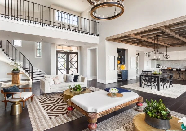 Panorama view of luxury home interior with open concept floor plan featuring living room, dining room, kitchen, and entry, with an elegant staircase leading to second floor.