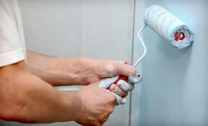 Man Painting Wall with Paint Roller