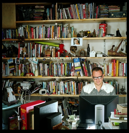 Man Sitting in an Office Surrounded by Books