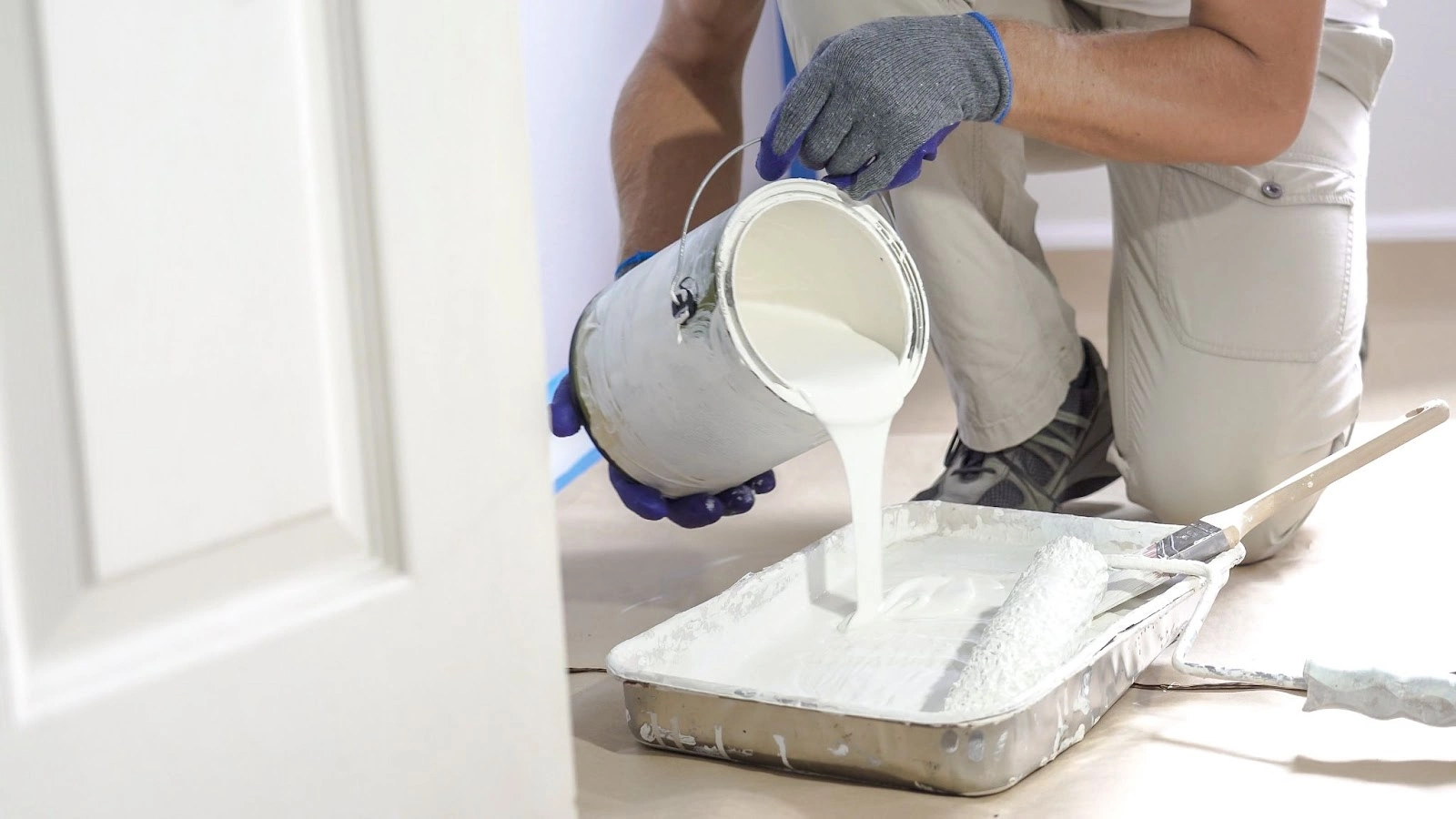 Five Star Painting service professional pouring paint into a paint tray.