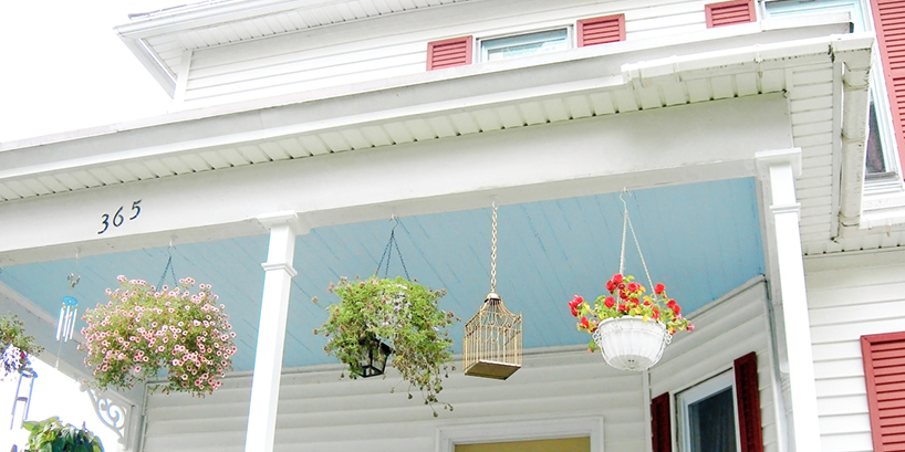 Photo of a porch ceiling painted sky blue on a two story house