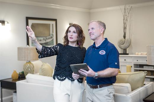 Five Star Painting technician talking to a woman in a living room