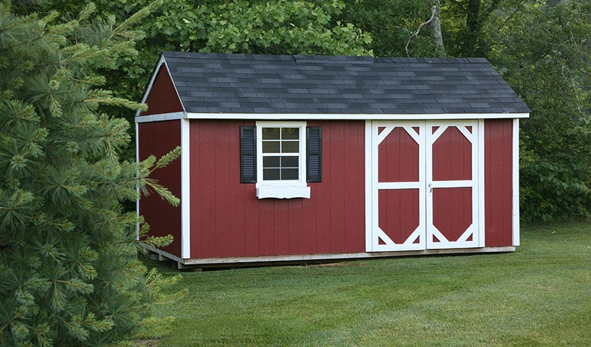 Red garden shed on grass lawn