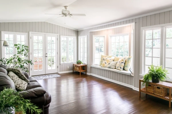 Large and open sunroom with windows on two sides and lots of natural light flowing in.