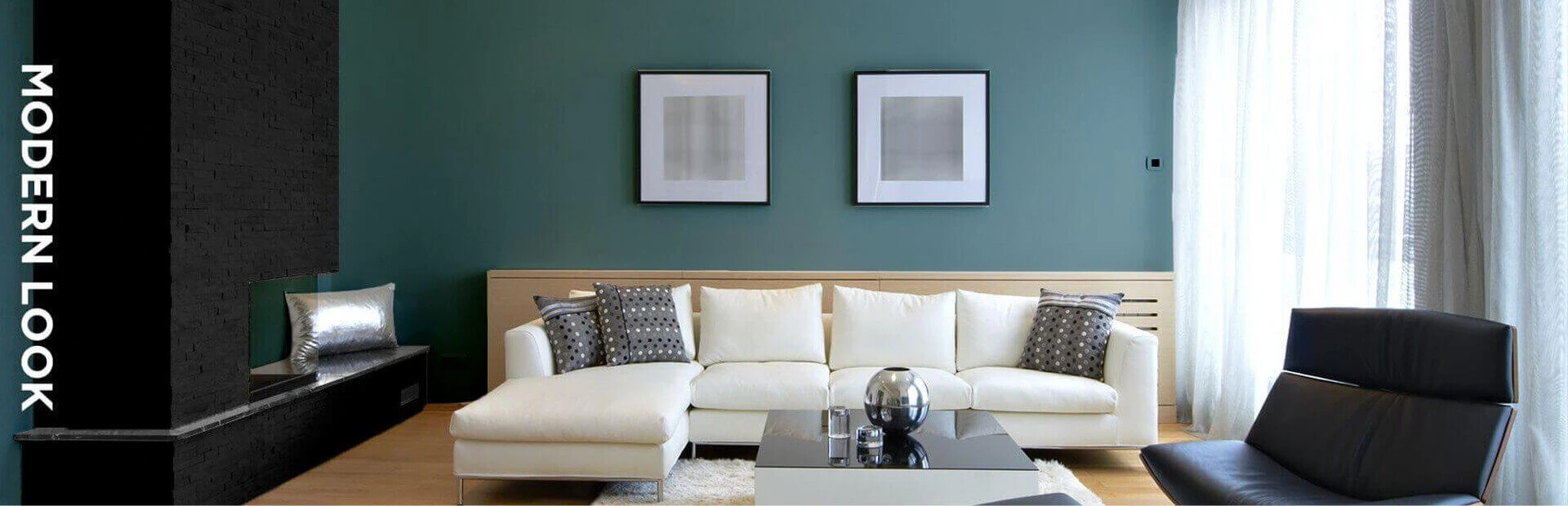 Living room in black, off-white, and green, featuring furniture and paintings on walls.