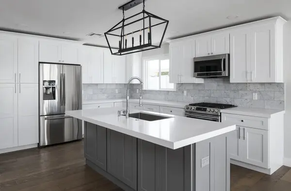 A kitchen with silver white cabinets and stainless steel appliances