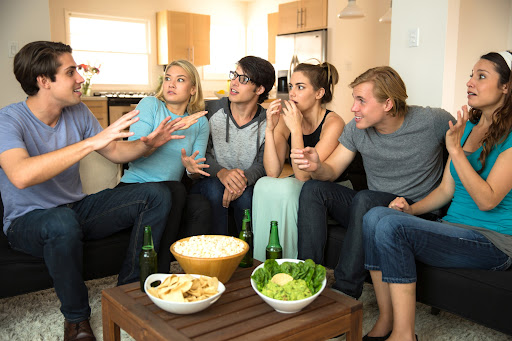 a group of friends sitting on a couch with food