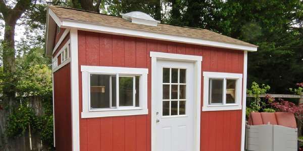 red outdoor shed with white windows and door
